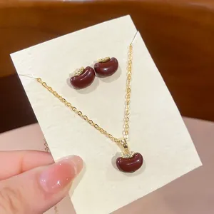 Gold-plated apple jewelry set with red resin pendant necklace and matching stud earrings