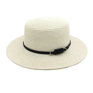 Détail d'un chapeau de paille d'été avec ceinture en cuir noir et boucle en métal argenté