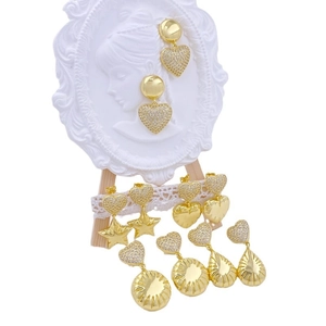 Golden geometric earrings with star and heart pendants featuring shimmering zircons