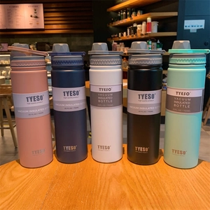 Five 750ml vacuum insulated water bottles in matte colors displayed on a cafe table