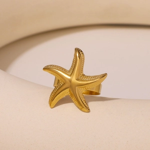 Starfish open ring in 18K gold plated stainless steel on a white ceramic display