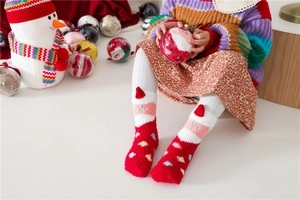 Close-up of thick red and white Christmas coral fleece socks with 3D cartoon design