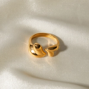 Bague cœur irrégulière dorée en acier inoxydable sur fond de soie blanche élégante