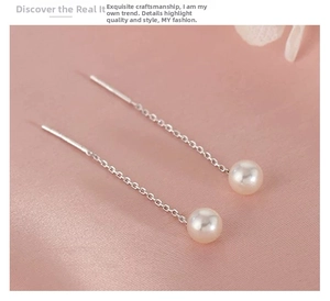 Détail de boucles d'oreilles en argent S925 avec perles blanches sur un tissu en soie rose
