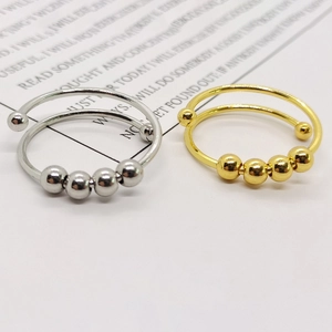 Close-up of gold and silver stainless steel anxiety rings with rotating beads