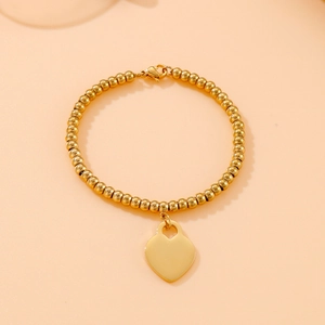 Detailed shot of 18k gold plated stainless steel bead bracelet with a heart pendant