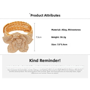 Detailed view of golden mesh bracelet with large rhinestone encrusted flower design
