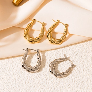 Macro shot of twisted rope hoop earrings in gold and silver finish with metallic texture