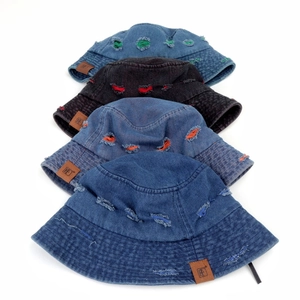 Distressed denim bucket hats in four colors with colorful patches and leather labels
