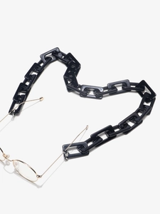 Detail of black acrylic square link glasses chain arranged in a heart shape layout