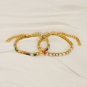 Golden stainless steel tennis bracelet with mixed colorful zircons on a silk background