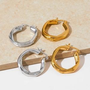 Minimalist irregular twisted gold and silver stainless steel hoop earrings on stone base