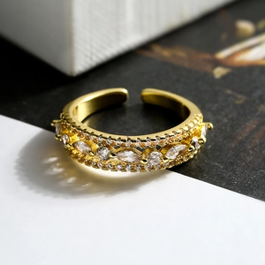 Macro shot of gold-plated open ring featuring multi-row zircons and marquise cut stones