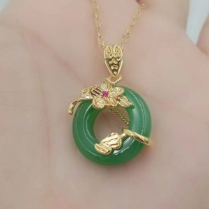 Jade-style circular pendant necklace with gold floral detail and red gemstone accent