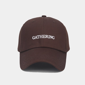 Détail de la broderie GATHERING sur casquette de baseball marron foncé en coton