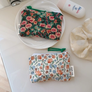 Détail de porte-monnaie en coton fleuri avec zips et imprimés de peinture à l'huile