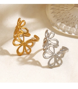 Close-up of gold and silver flower rings on soft beige silk background decor