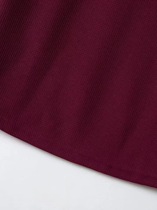 Primo piano del tessuto a maglia a coste bordeaux scuro con dettagli di cucitura di qualità