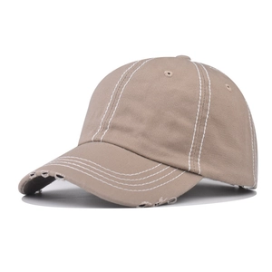 Detail of khaki washed cotton baseball cap featuring vintage distressed edges and white stitching