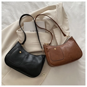 Detailed view of vintage black and brown leather underarm bags with adjustable straps