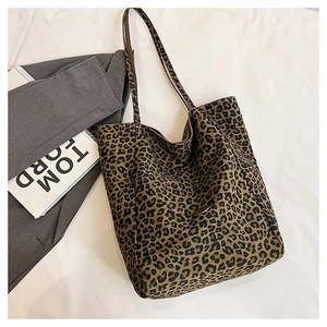 Close-up of leopard print tote bag with metal plaque on soft white background
