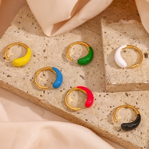 Colorful teardrop enamel drip oil open rings in gold finish on beige stone background