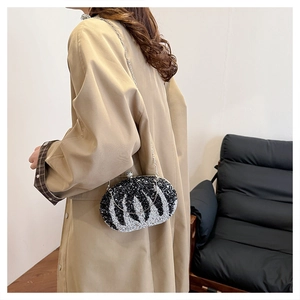 Close-up of wavy black and white sequined evening clutch bag with delicate metal chain