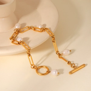Macro detail of OT toggle clasp and freshwater pearls on golden paperclip link chain