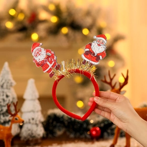 Détail du serre-tête de Noël avec poupées Père Noël et glands à franges dorées
