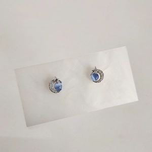 Detail of star and moon stud earrings with blue cat eye stone and micro zircon