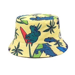 Detail of vibrant yellow bucket hat with cartoon dinosaurs and summer surfing patterns