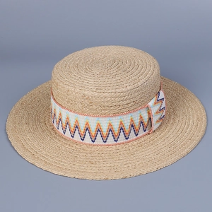 Detailed texture of hand-woven raffia flat top sun hat with colorful geometric ribbon