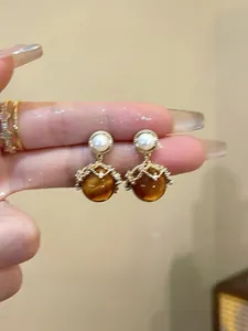Detailed view of vintage earrings with pearls, amber beads, and 18K gold-plated metal