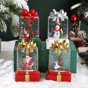 Christmas LED water globe lantern with festive Santa and snowman scenes on snowy display