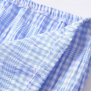 Blue and white gingham two-piece set featuring elastic smocked texture and refined fabric detail