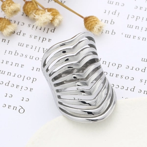 Detailed view of silver wide-band wavy textured steel ring on vintage paper background