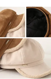 Detail of suede and faux shearling baker boy hat with gold tag and quilted lining