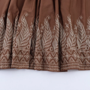 Robe longue marron élégante avec broderies blanches complexes et manches bouffantes