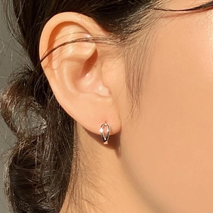 Close-up of elegant gold teardrop earrings worn by a model for a minimalist fashion look