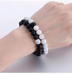 Detail of 8mm volcanic stone and white turquoise bead bracelets worn on wrist