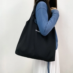 Grand sac cabas noir en toile avec imprimé Simplicity porté pour voyage et cours
