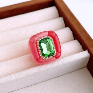 Detailed close-up of a vintage resin ring with emerald-cut green gemstone and pave crystals