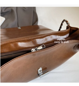 Detail view of smooth zipper closure and striped fabric lining inside a brown tote bag
