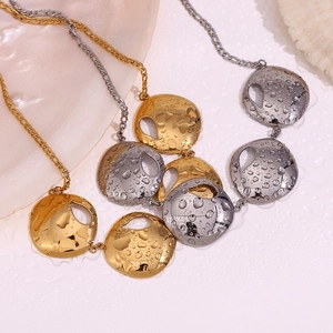 Detailed close-up of 18K gold and silver plated necklaces with water droplets on a shell