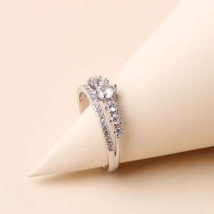 Macro shot of silver crown ring with sparkling diamonds on a beige display stand