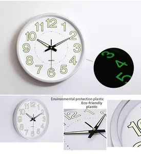 Detail of 12-inch silver wall clock showing glowing luminous dial and quartz movement
