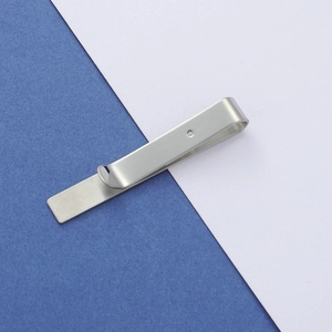 Macro shot of silver stainless steel tie clip with brushed texture and mirror polished finish