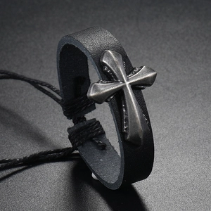 Close-up of vintage braided leather bracelet with silver metal cross and adjustable cord
