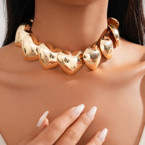 Close-up of a chunky golden heart choker featuring 3D metallic mirror finish elements
