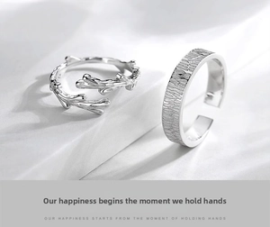 Macro shot of branch-shaped open ring and textured wide band silver couple rings